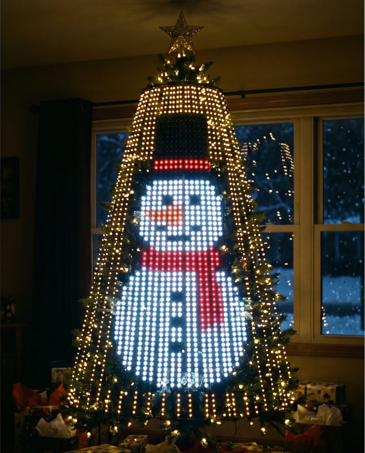 A Christmas tree lit with the Snowman design